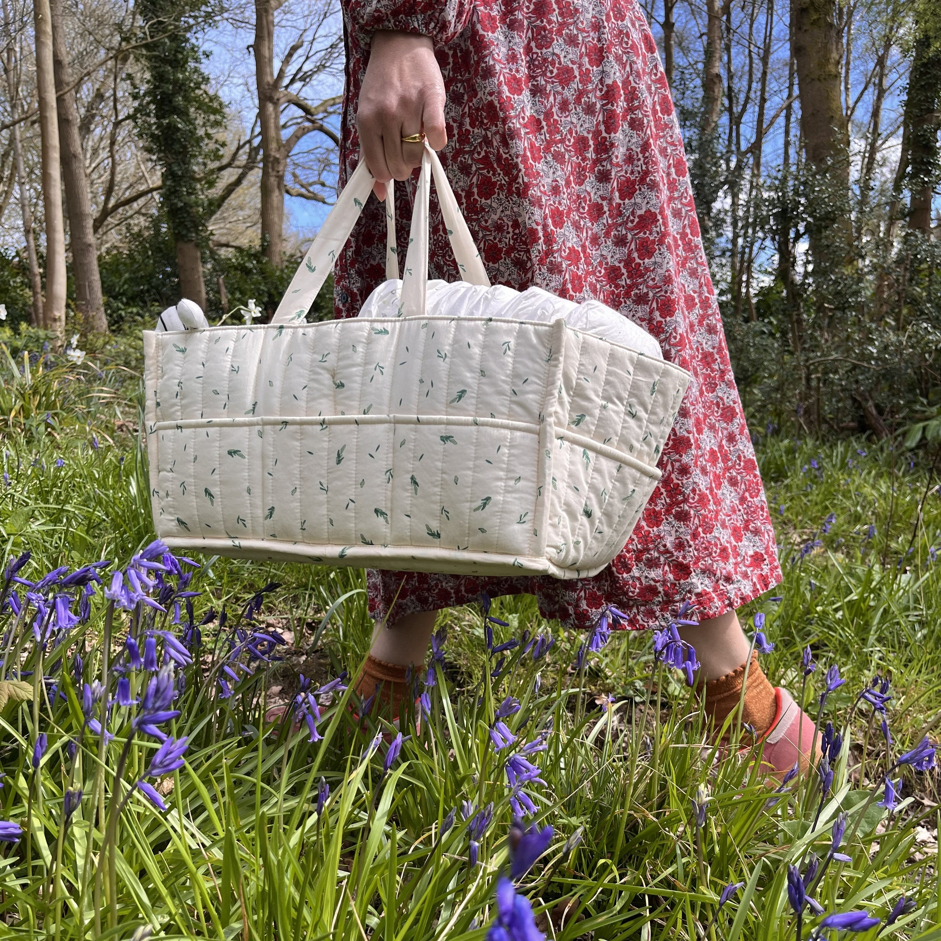 Organic cotton nappy caddy being carried outdoors in a natural setting