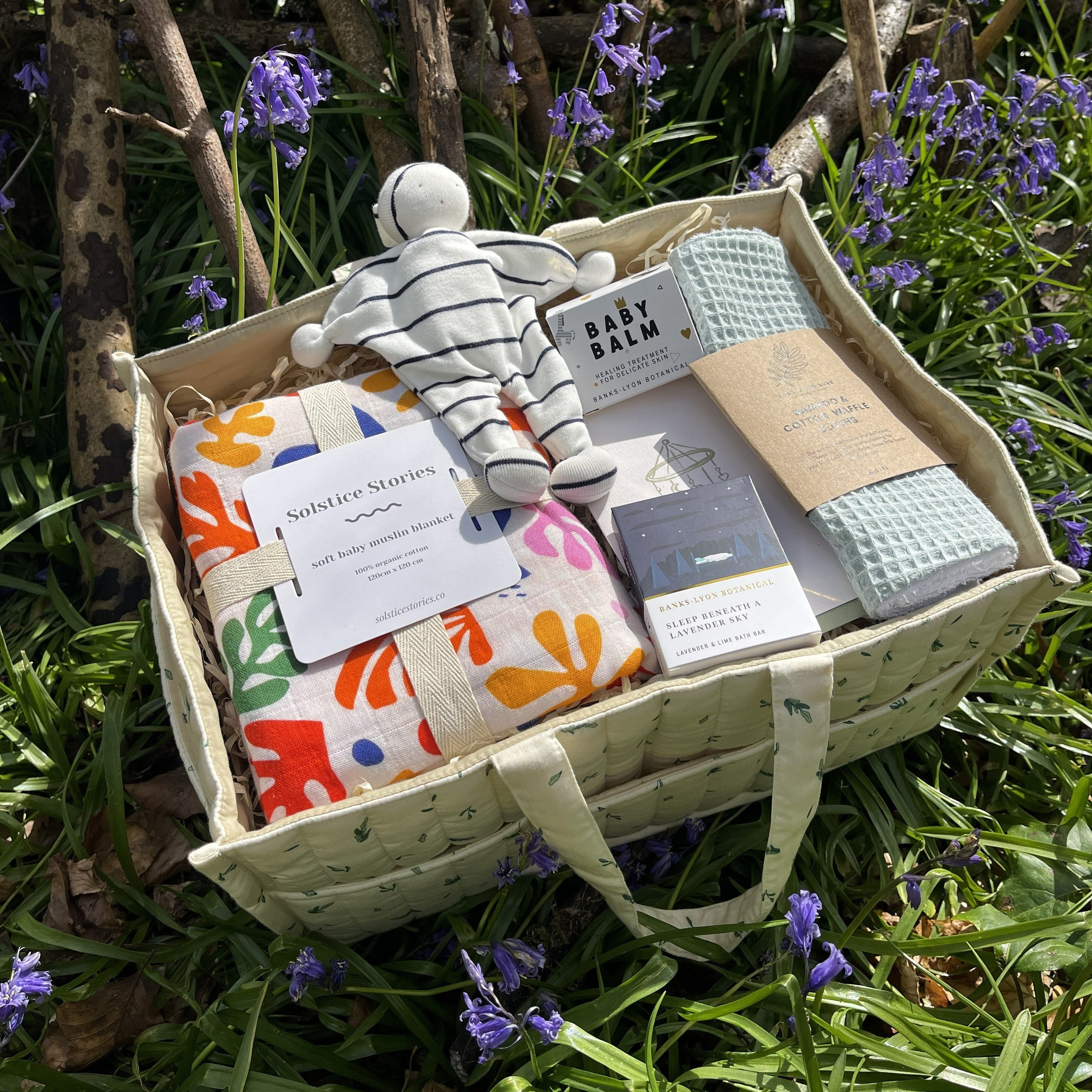 New baby gift hamper set displayed outdoors with organic baby essentials