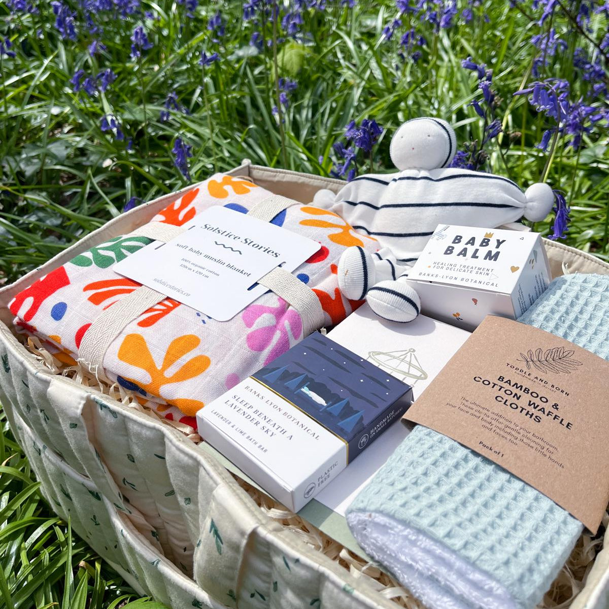Open baby gift hamper with organic cotton items and natural baby products