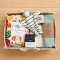 Organic baby gift hamper with nappy caddy, muslin swaddle, comforter toy and baby essentials 
