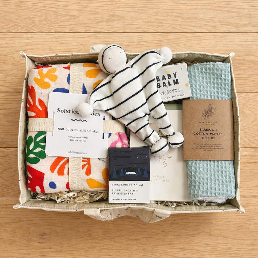 Organic baby gift hamper with nappy caddy, muslin swaddle, comforter toy and baby essentials 
